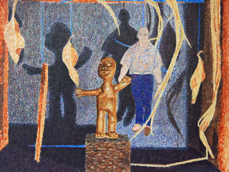 Wooden african figure in the foreground with a man standing the background